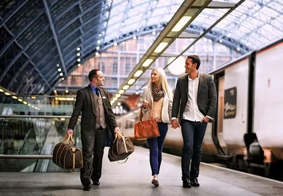 Chauffeur at Bourg-Saint-Maurice carrying the luggage of two guests on the station platform